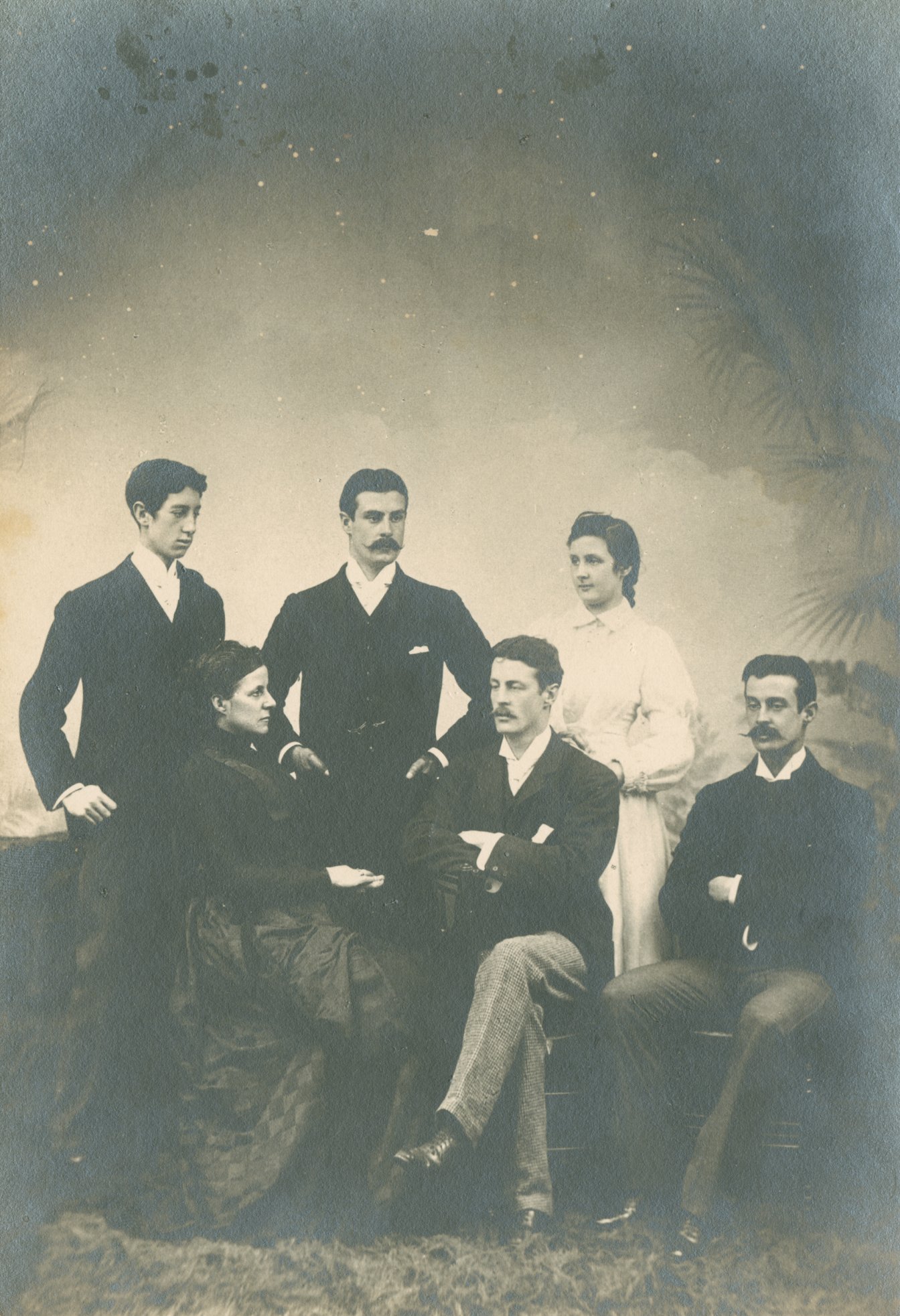 Black and white family photograph of four men and two women in period dress