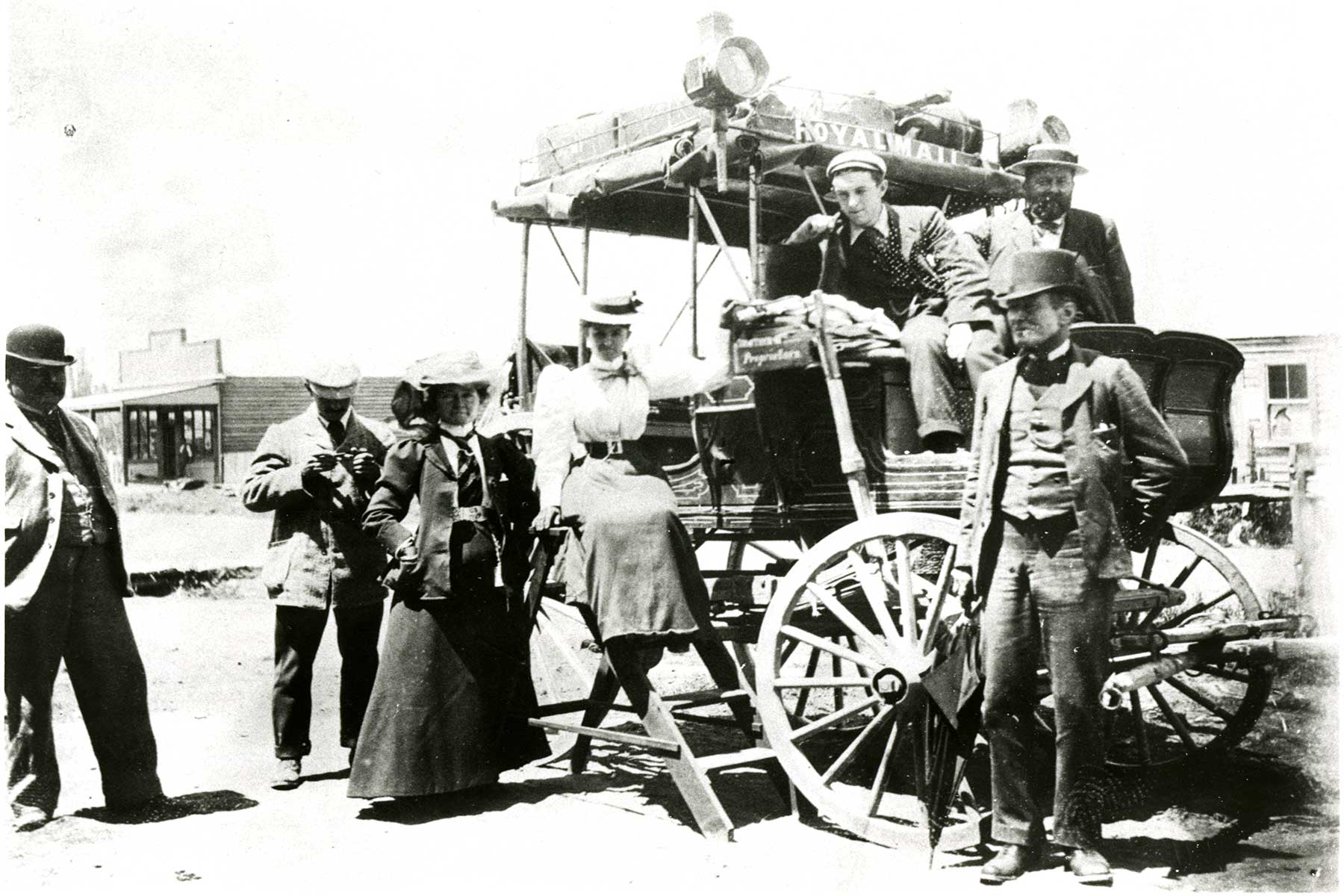 Group standing by a stage coach, New Zealand, 1897