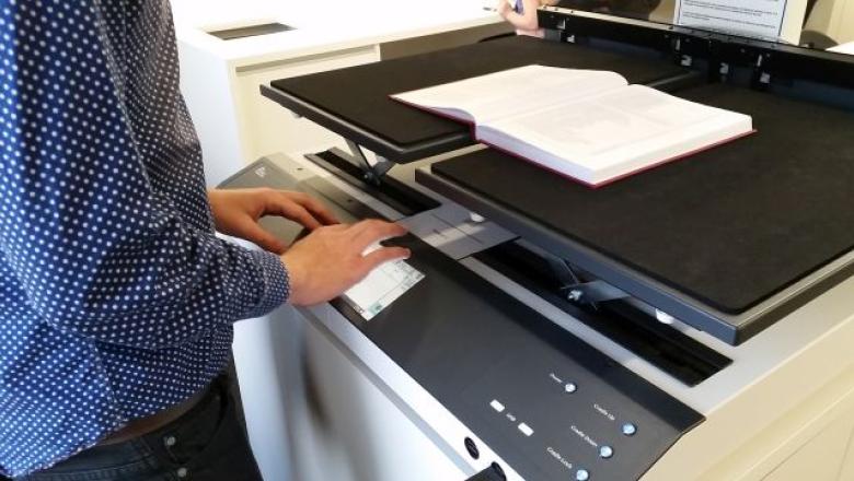 An open book on the cradle of the Book Eye scanner. The right panel has been lowered so the book is flat.