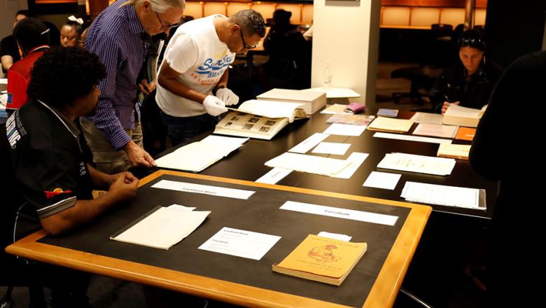 Participants of the annual Indigenous Knowledge Centre Coordinator’s Workshop examine special collection items in the Fryer Library's FW Robinson Reading Room. 