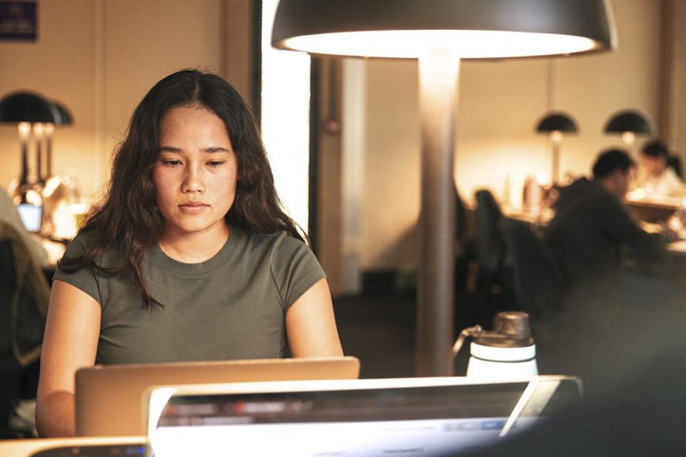 Student studying at a desk with a low-light lamp.