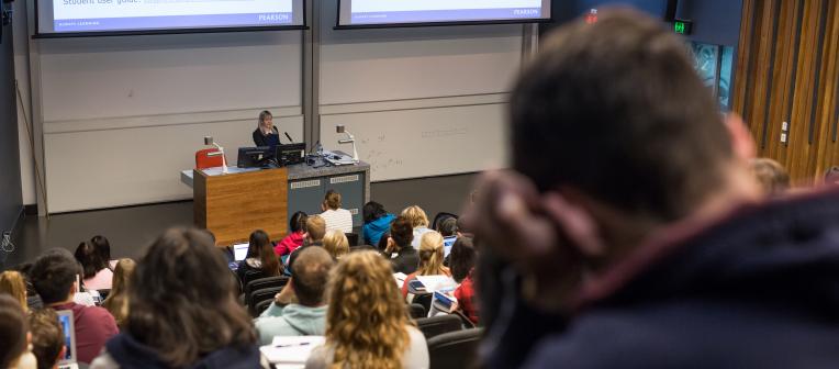 Students seated in lecture theatre, lecturer at the front