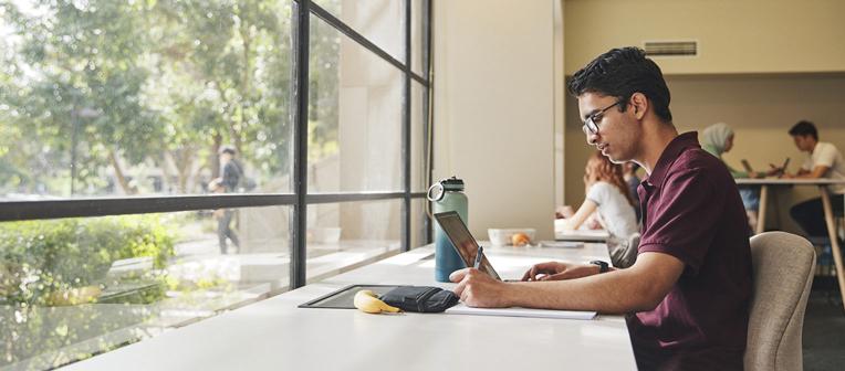 person on laptop in front of a window