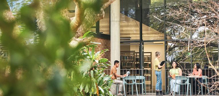 Students chatting and studying outside at JK Murray Library on Gatton campus.