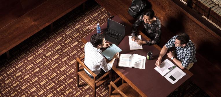 Students studying at a group table in the Walter Harrison Law Library.