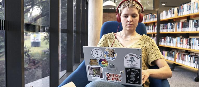 Student with headphones and laptop.
