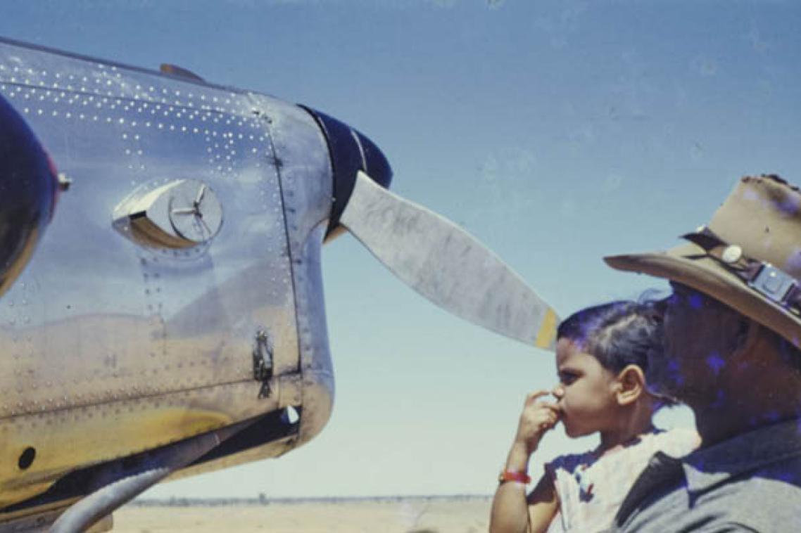 Man and child looking at a propeller plane