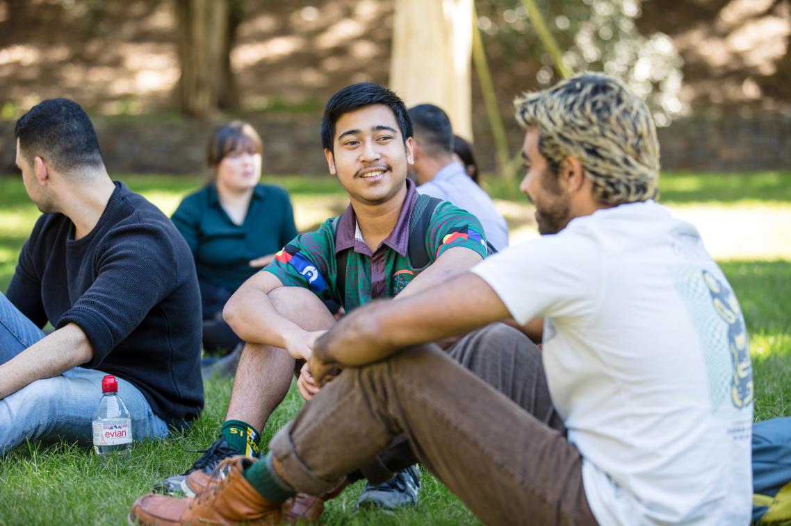 Groups of students seated on grass