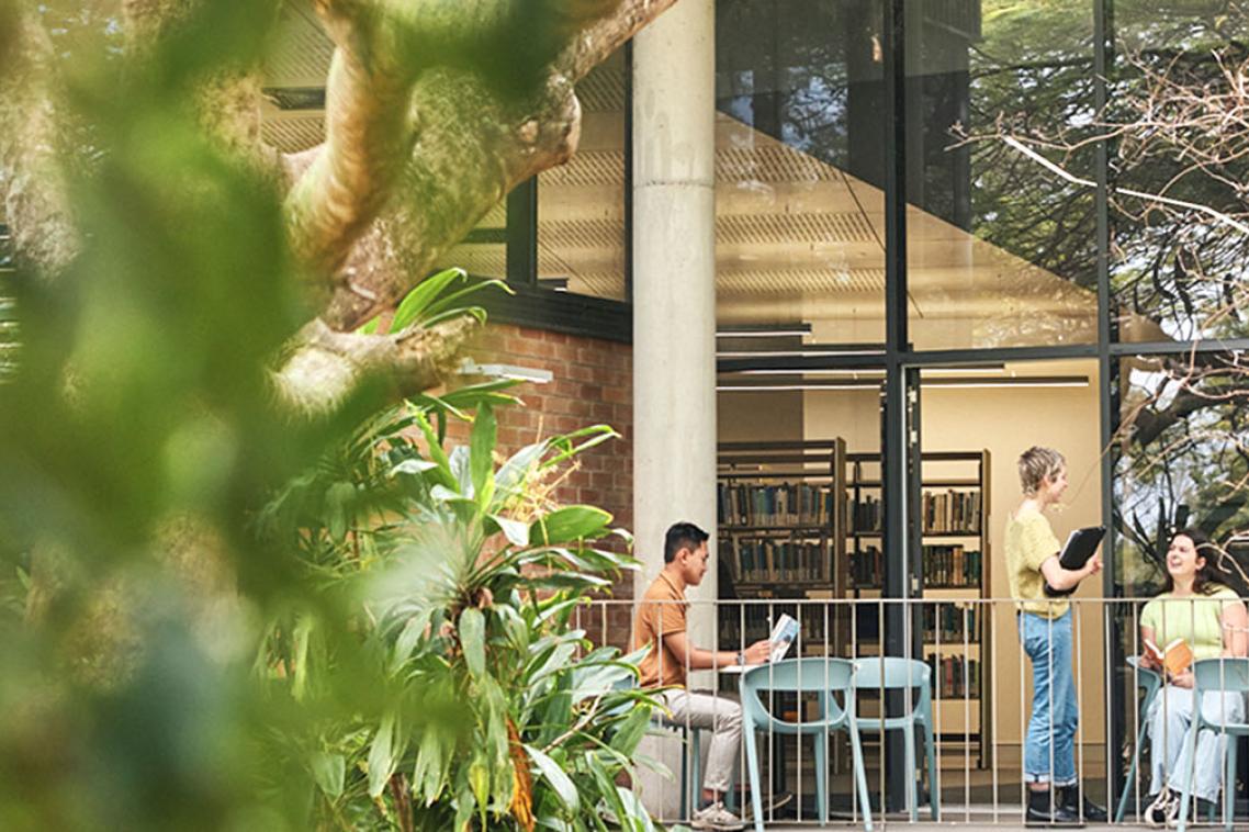 Students chatting and studying outside at JK Murray Library on Gatton campus.
