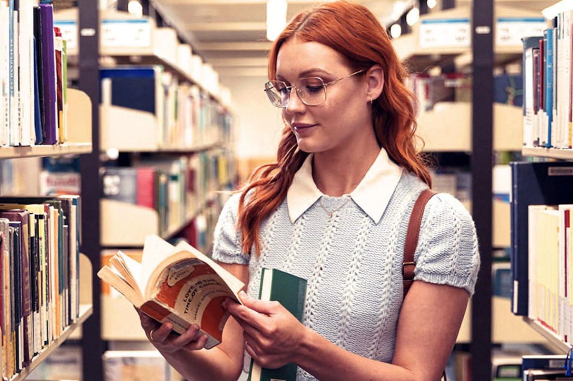 student reading a book in the library