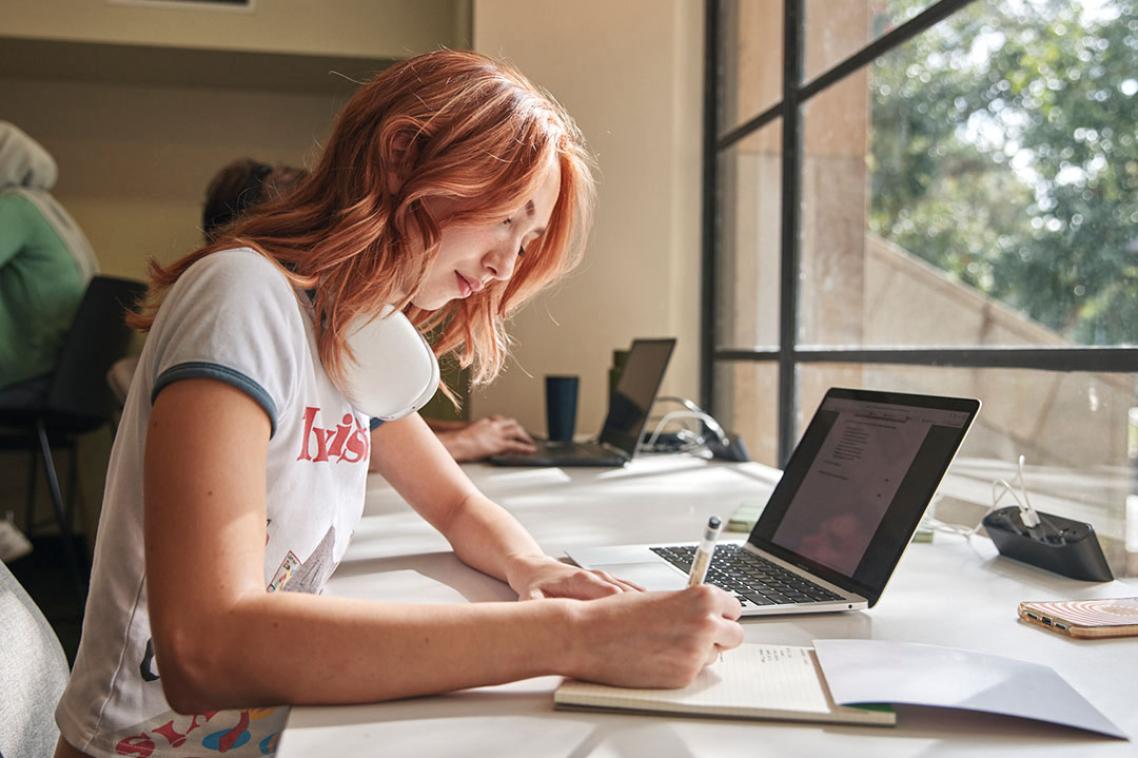 Student sitting at a desk in front of a window