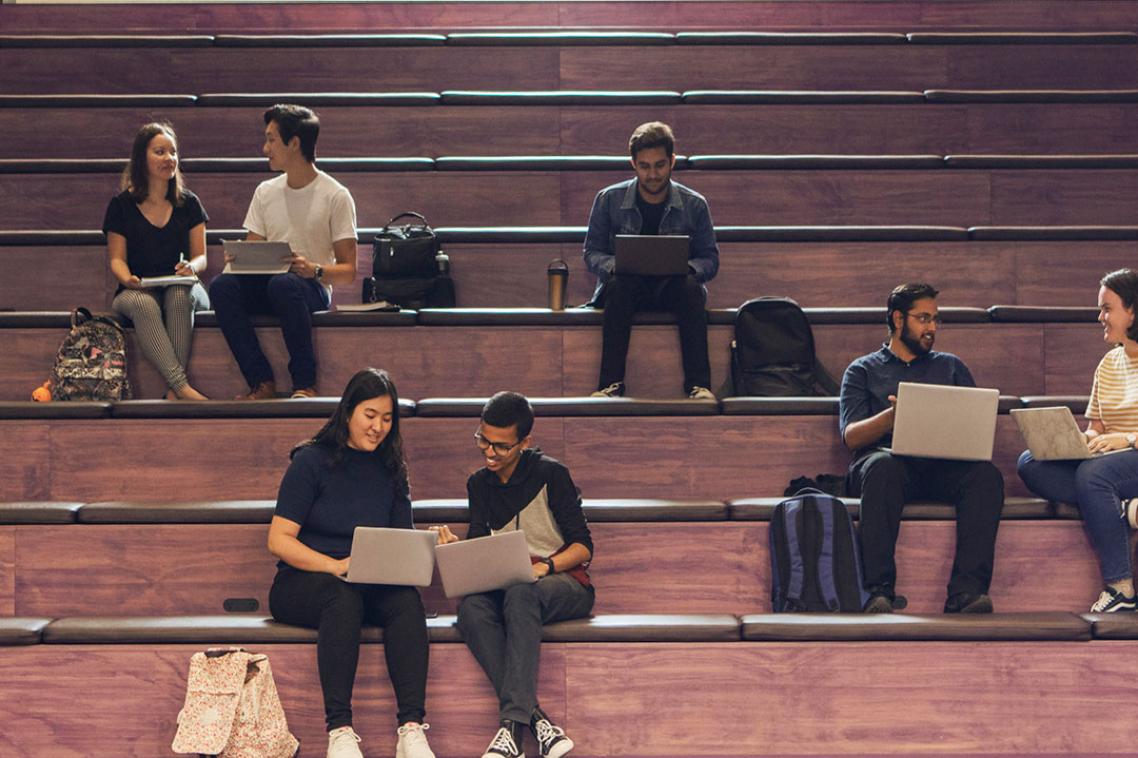 students using laptops in central library purple stairs