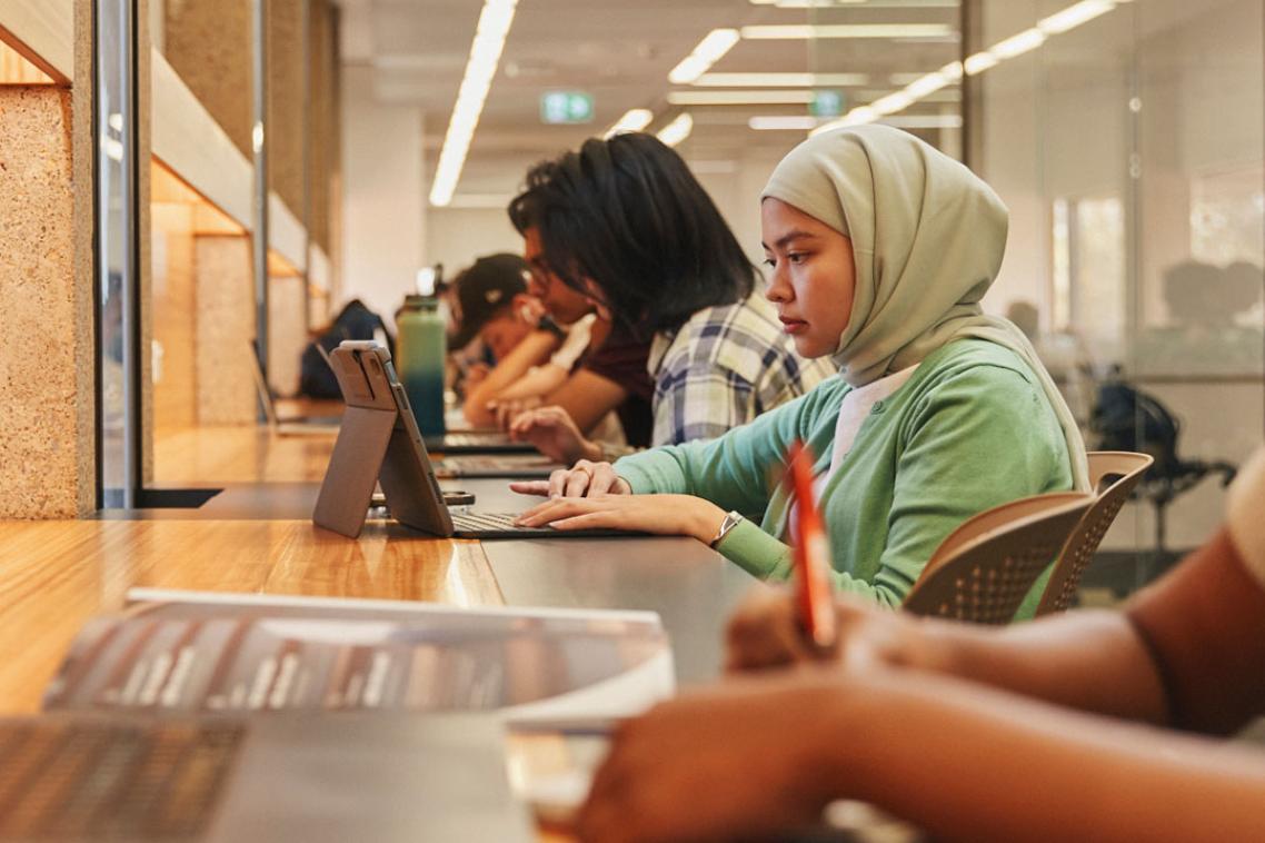 student using laptop in central library