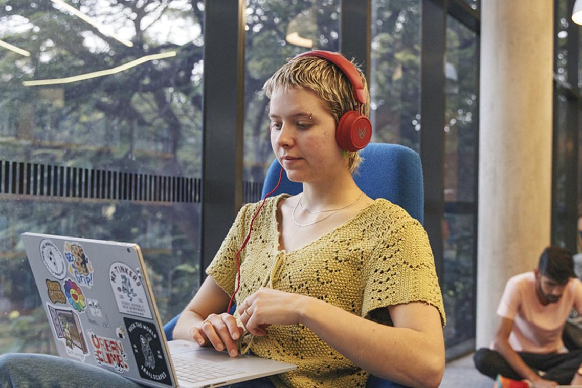 Student with headphones on laptop.