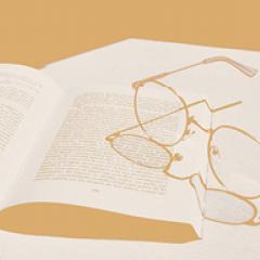 Open book with glasses sitting on top